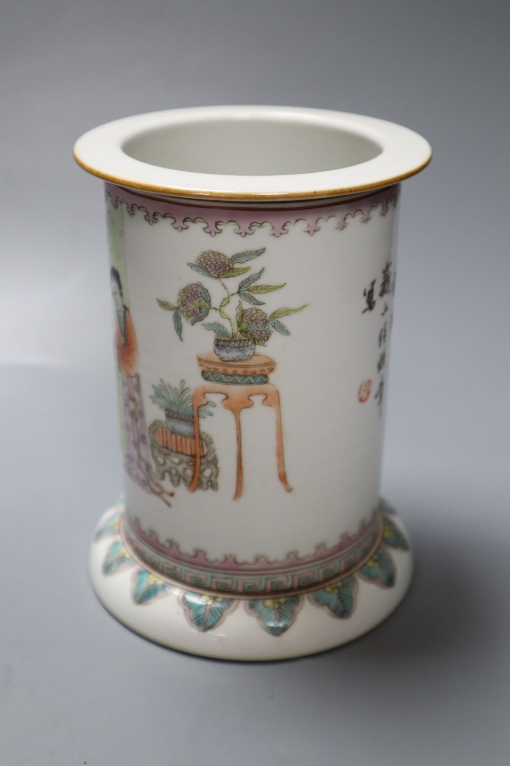 A Chinese cylindrical porcelain brush pot, enamelled with female figures and script, 15cm